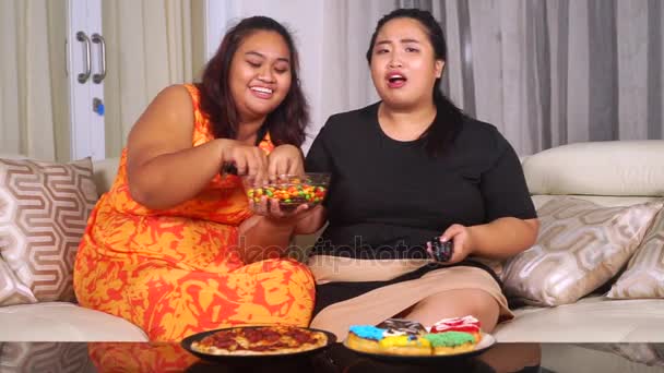 Overweight women eating chocolate candies — Stock Video