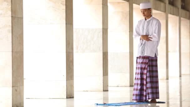 Молодой мусульманин молится в мечети — стоковое видео