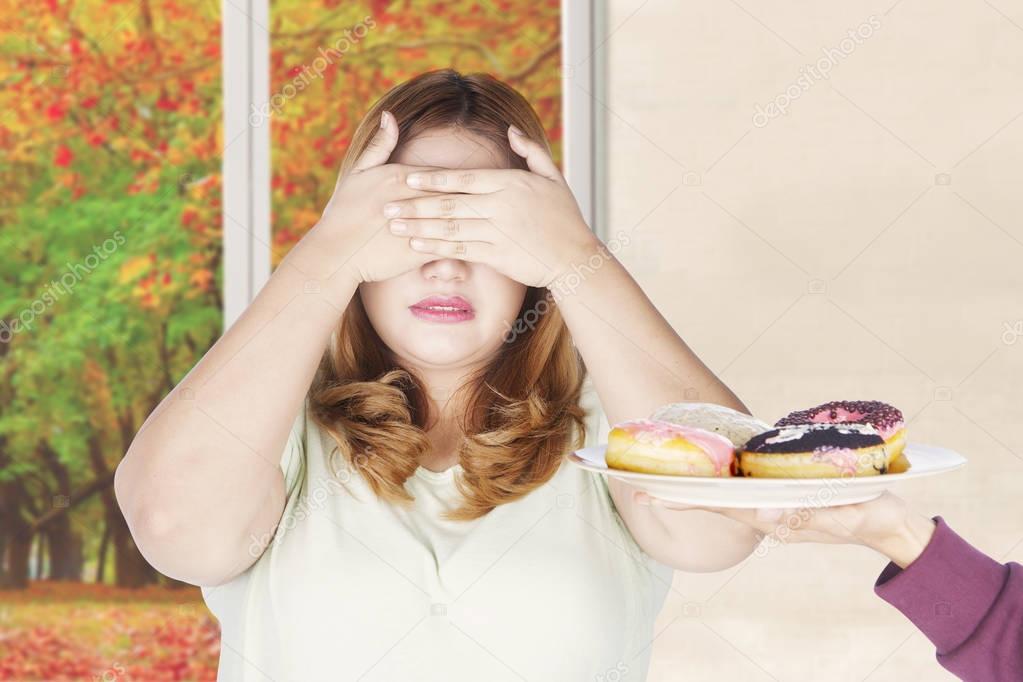 Blonde hair woman closed eyes for donuts 