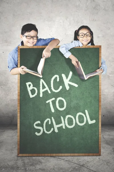 Elementary students behind a chalkboard — Stock Photo, Image