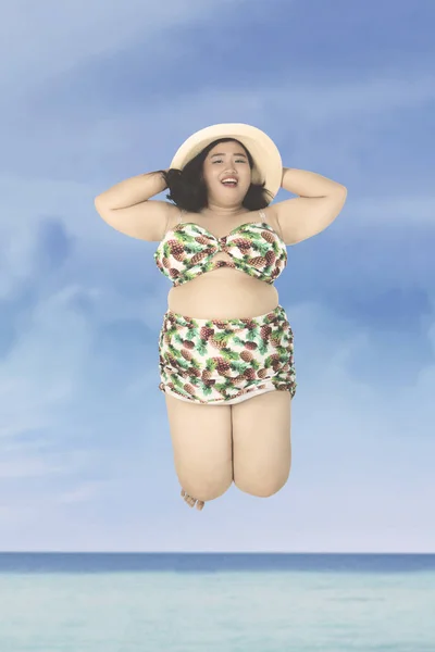 Fat woman jumping on beach — Stock Photo, Image