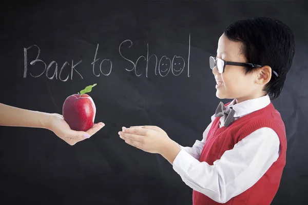 Kid recibe manzana con texto Volver a la escuela — Foto de Stock