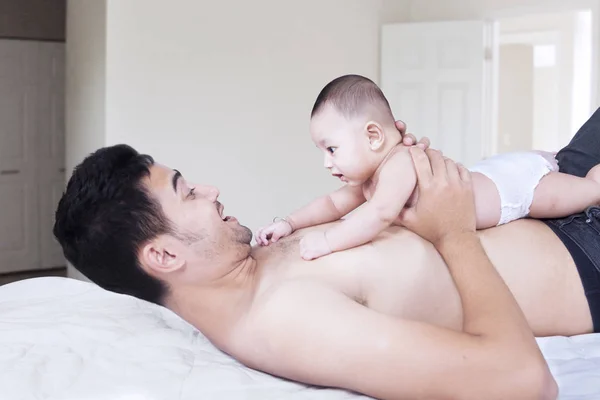 Niño tendido en el pecho del padre en el dormitorio —  Fotos de Stock