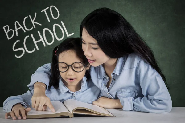 Liten flicka och lärare bok en — Stockfoto