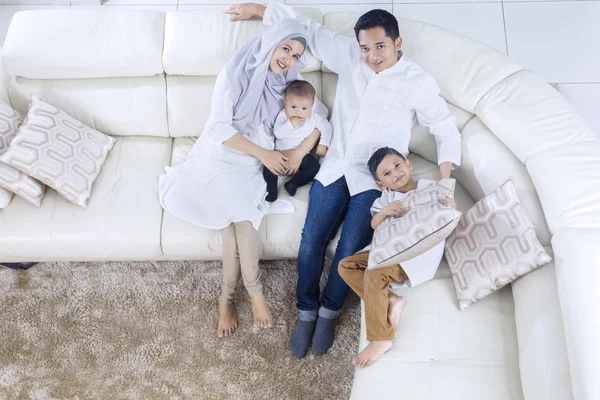 Padres musulmanes y niños relajándose en el sofá —  Fotos de Stock