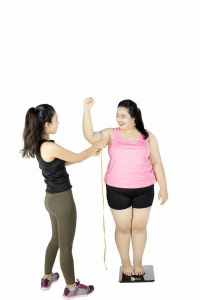 Entrenador que mide bíceps de mujer gorda — Foto de Stock