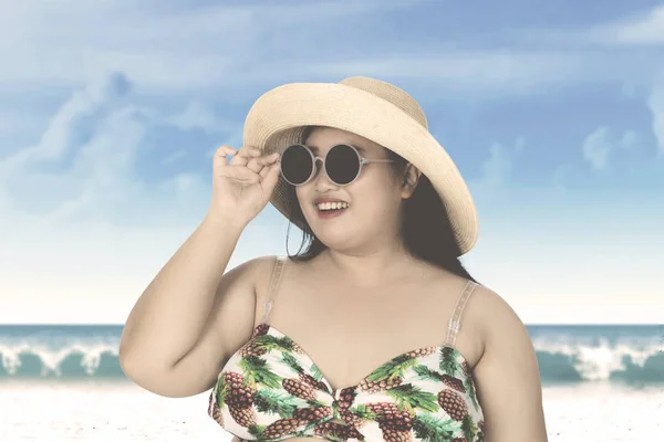 Žena s kloboukem a sluneční brýle na pobřeží — Stock fotografie