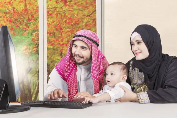 Arabian family using a computer in autumn