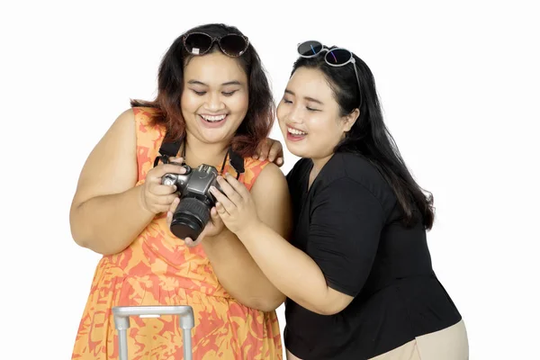 Mulheres alegres olhando para a câmera digital — Fotografia de Stock