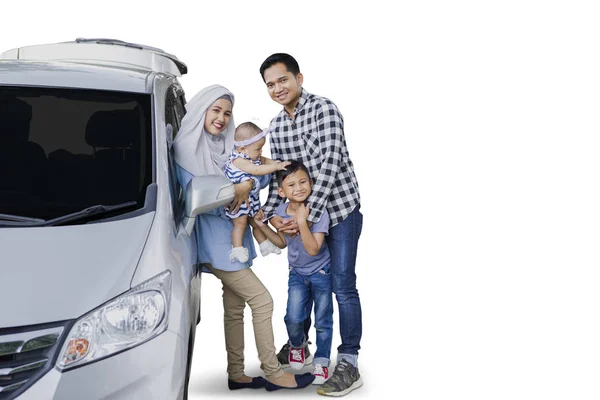 Família de pé ao lado de um carro no estúdio — Fotografia de Stock