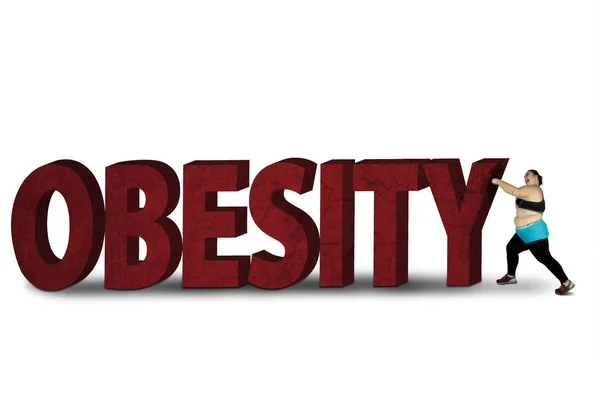 Fat woman crushing word of obesity — Stock Photo, Image