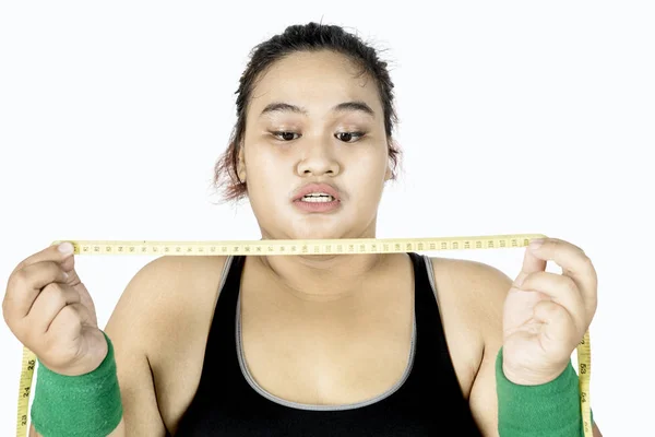 Mulher gorda olhando fita métrica — Fotografia de Stock