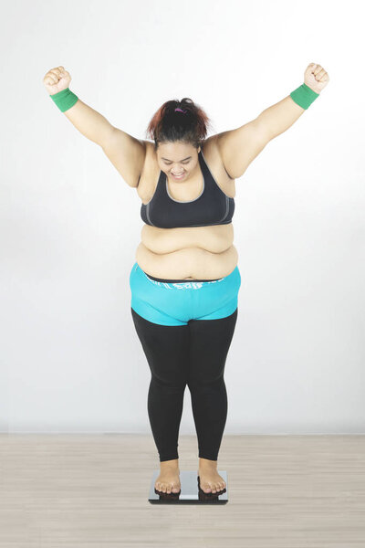 Fat woman looking weight scale