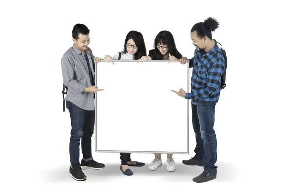 Multirassische Studenten zeigen ein leeres Brett im Atelier — Stockfoto