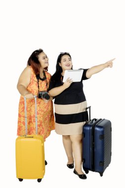 Dijital tablet ile bir şey işaret eden turistler 