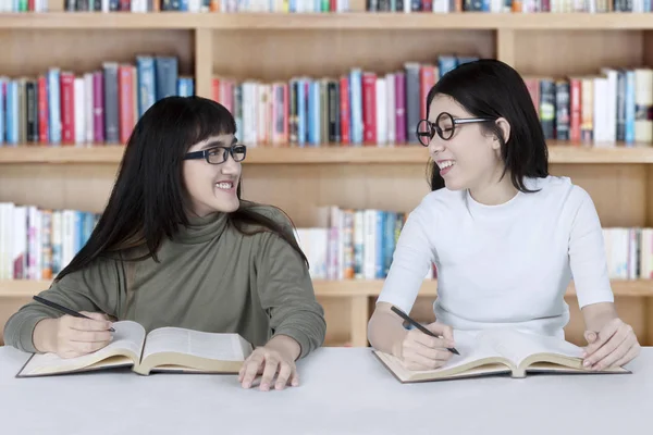 Две студентки учатся в библиотеке — стоковое фото