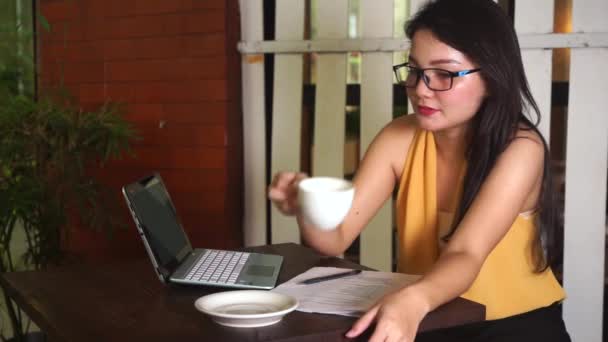 Mulher bebe café enquanto trabalha no café — Vídeo de Stock