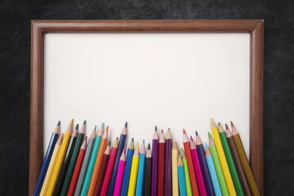 Pensil berwarna dan bingkai kosong dengan papan tulis — Stok Foto