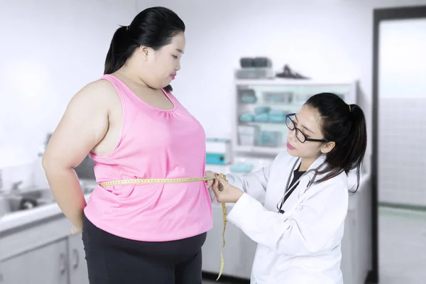 Läkaren undersöker en patient fetma — Stockfoto