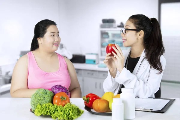 Lekarz tłumacząc zdrowej żywności dla jej pacjenta — Zdjęcie stockowe
