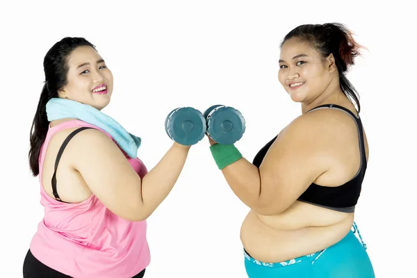Fat women train with dumbbells on studio — Stock Photo, Image