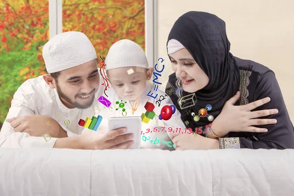 Happy muslim parents teaching math on bed — Stock Photo, Image