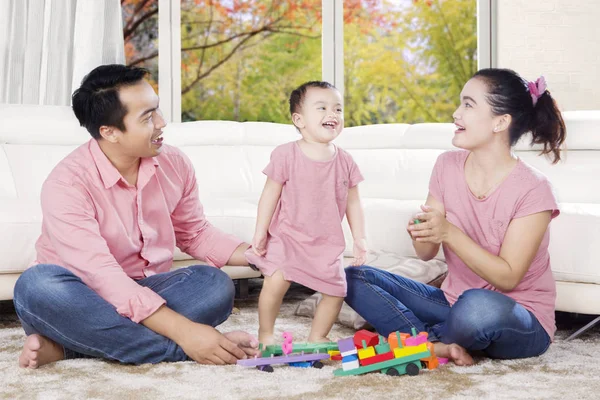 Pais felizes brincando com sua filha — Fotografia de Stock