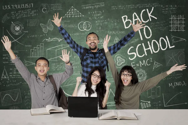 Happy students with scribble on chalkboard — Stock Photo, Image