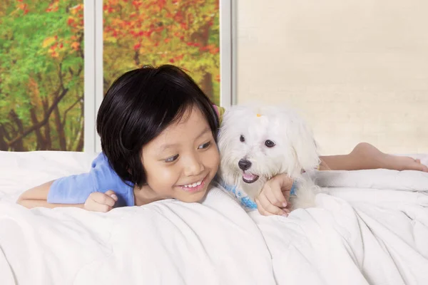 Kislány átölelve kutyaféle a hálószobában — Stock Fotó