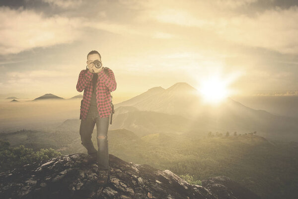 Man taking photo on mountain peak