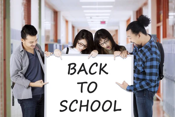 Students with Back to School text in corridor — Stock Photo, Image