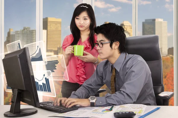 Secretaris kijkt manager gewerkt met een computer — Stockfoto
