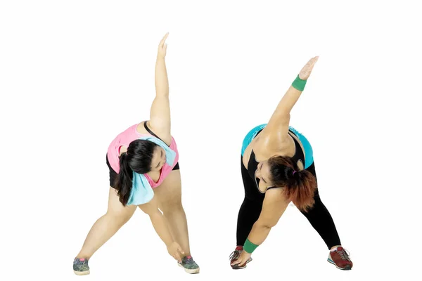 Två överviktiga kvinnor gör stretching på studio — Stockfoto