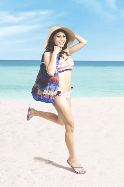 年轻女子在海滩上奔跑 — 图库照片