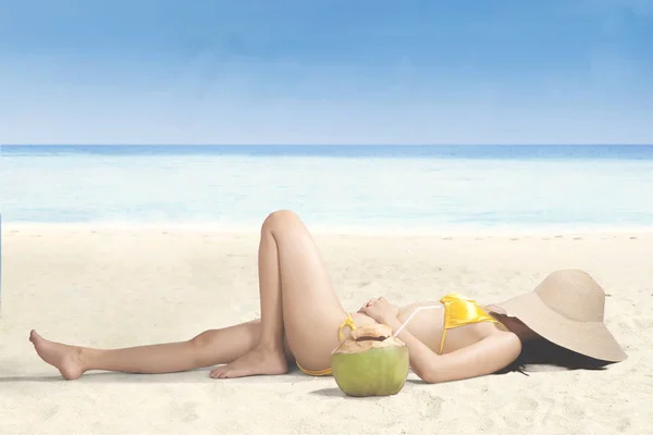 Junge Frau entspannt am Strand mit Hut — Stockfoto