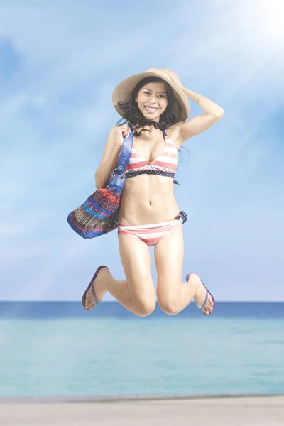 Mujer joven se ve feliz en la playa — Foto de Stock