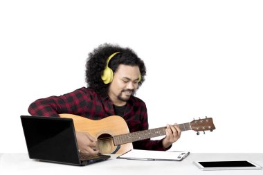 Afro adam bir gitar üzerinde stüdyo çalıyor.