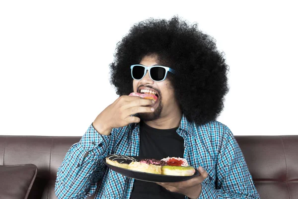 African man eating donuts — Stock Photo, Image