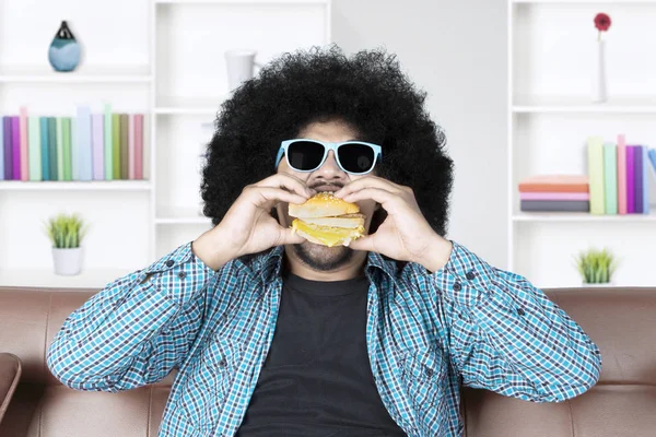 Afro férfi napszemüveg eszik hamburgert — Stock Fotó