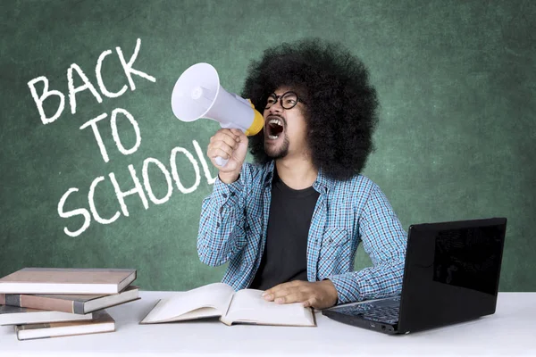 Angry male student with megaphone — Stock Photo, Image