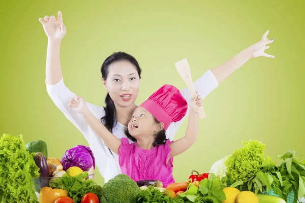 Vacker kvinna och dotter med grönsaker — Stockfoto