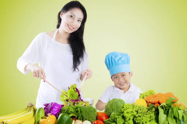 Hermosa mujer e hijo hacen ensalada — Foto de Stock