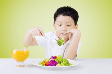 Sıkılmış çocuk salata alır