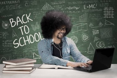 Erkek öğrenci sınıfta kulaklık kullanarak