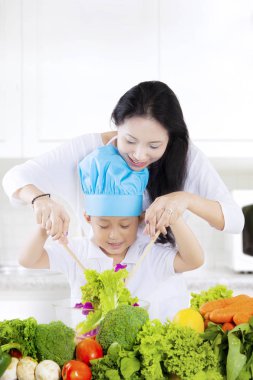 Anne ve oğlu öğle yemeği için salata yapmak