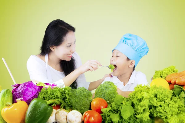 Pojken och hans mor provsmakning grönsakssallad — Stockfoto