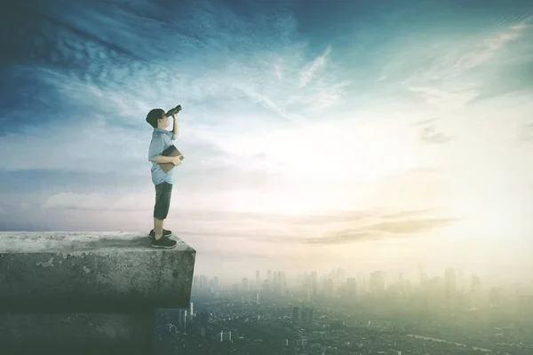 Boy looking with binoculars on rooftop — Stock Photo, Image