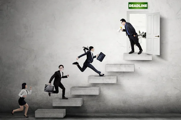 Businesspeople running toward deadline door — Stock Photo, Image