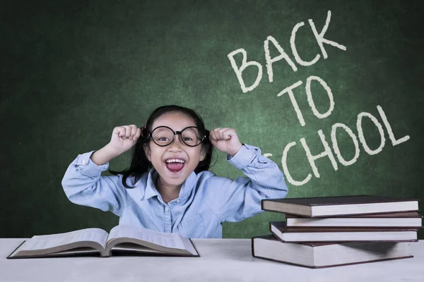 Cheerful schoolgirl with back to school word — Stock Photo, Image