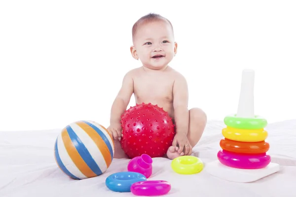 Niedliches Baby spielt mit buntem Spielzeug — Stockfoto